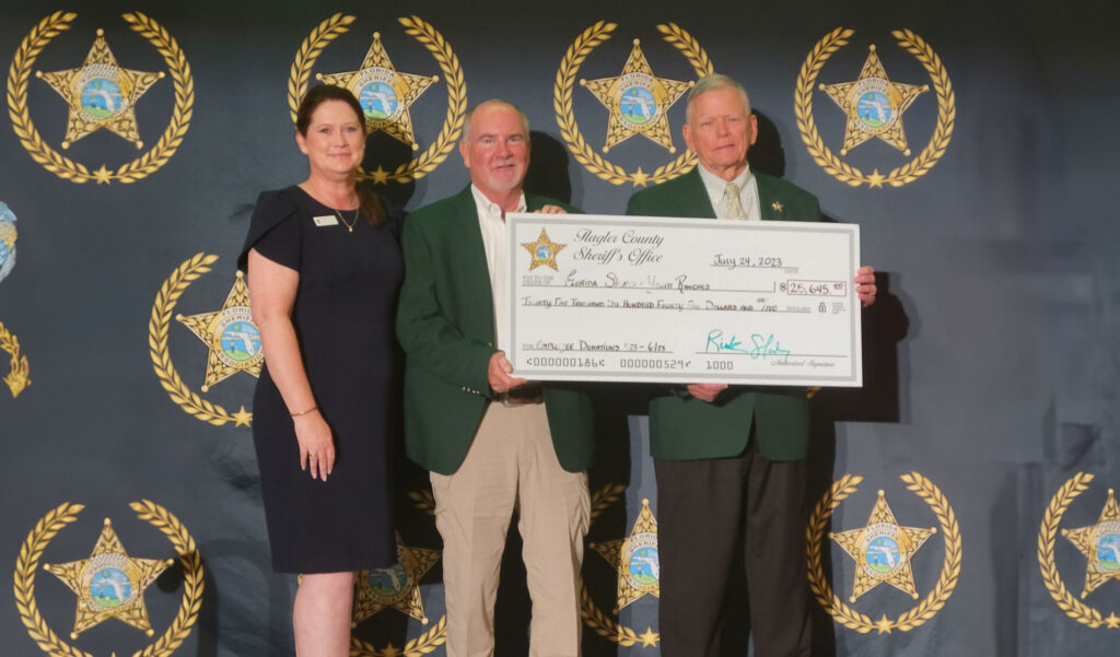 Flagler County Sheriff's Office officials presenting a giant cheque for $25,645 to Florida Sheriffs Youth Ranches
